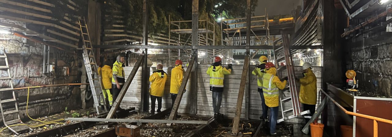 Mitarbeiter*innen der Wiener Linien errichten auf einer U-Bahn-Trasse einen Hochwasserschutz